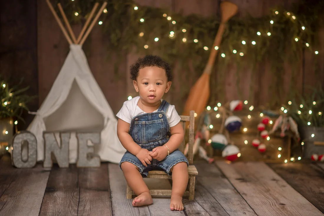 Birthday boy seated in a fishing-themed set with string lights