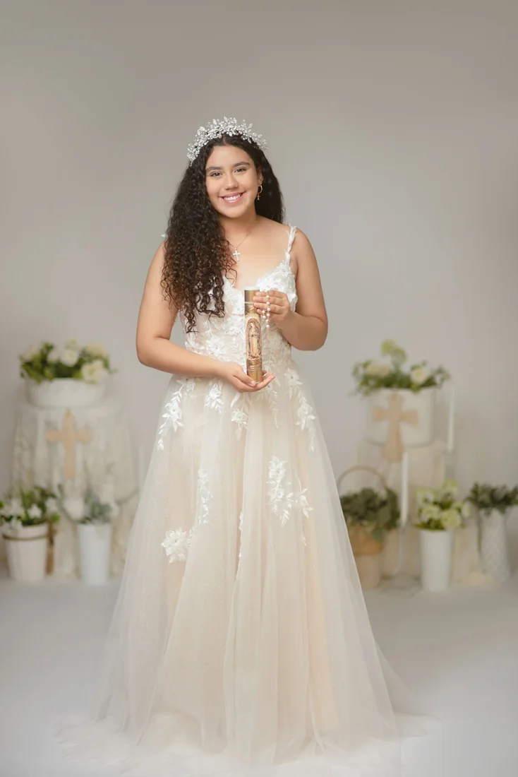 Girl in a white dress holding a candle for her Communion portrait