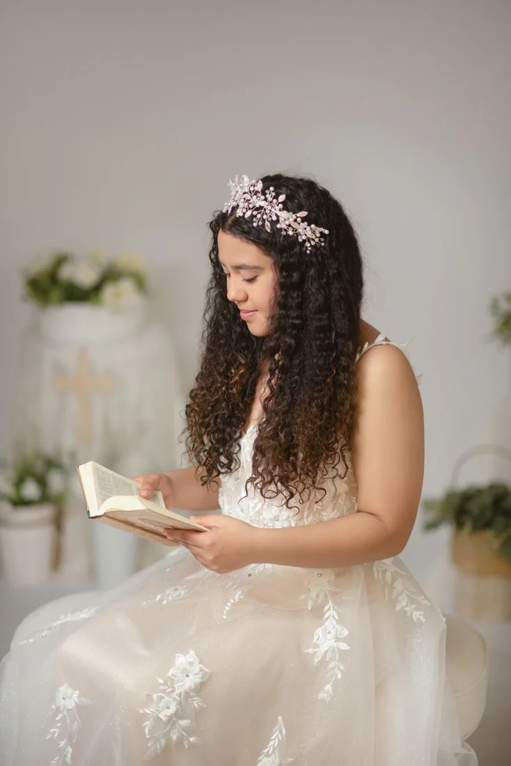 Girl seated in a white dress reading a book