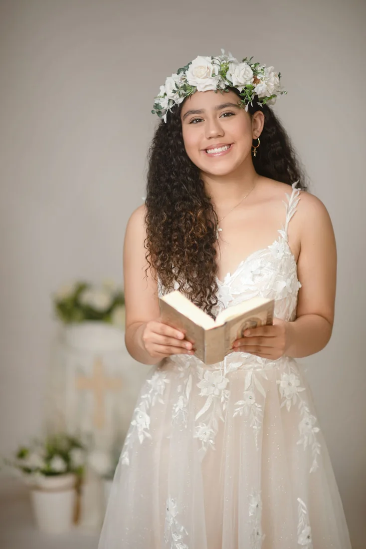Girl with a floral crown holding an open book