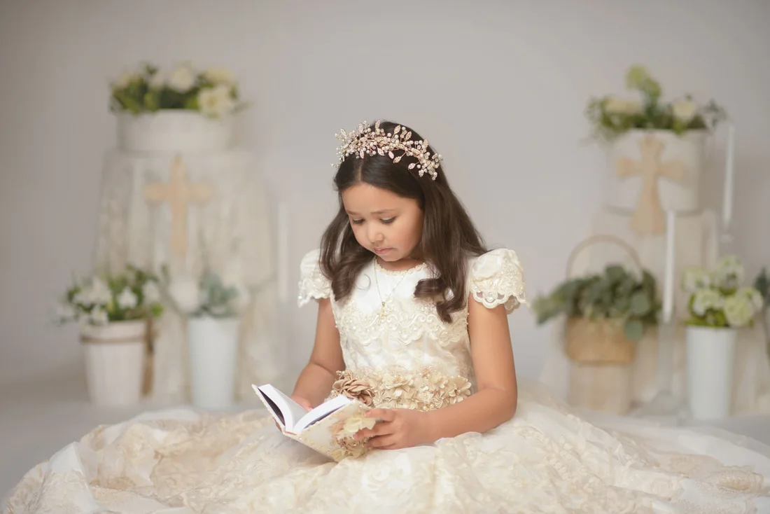Girl with a jeweled headband looking down at an open book