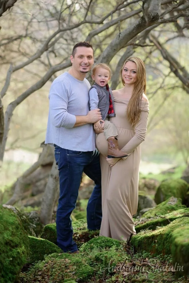 Maternity portrait in a long dress among trees