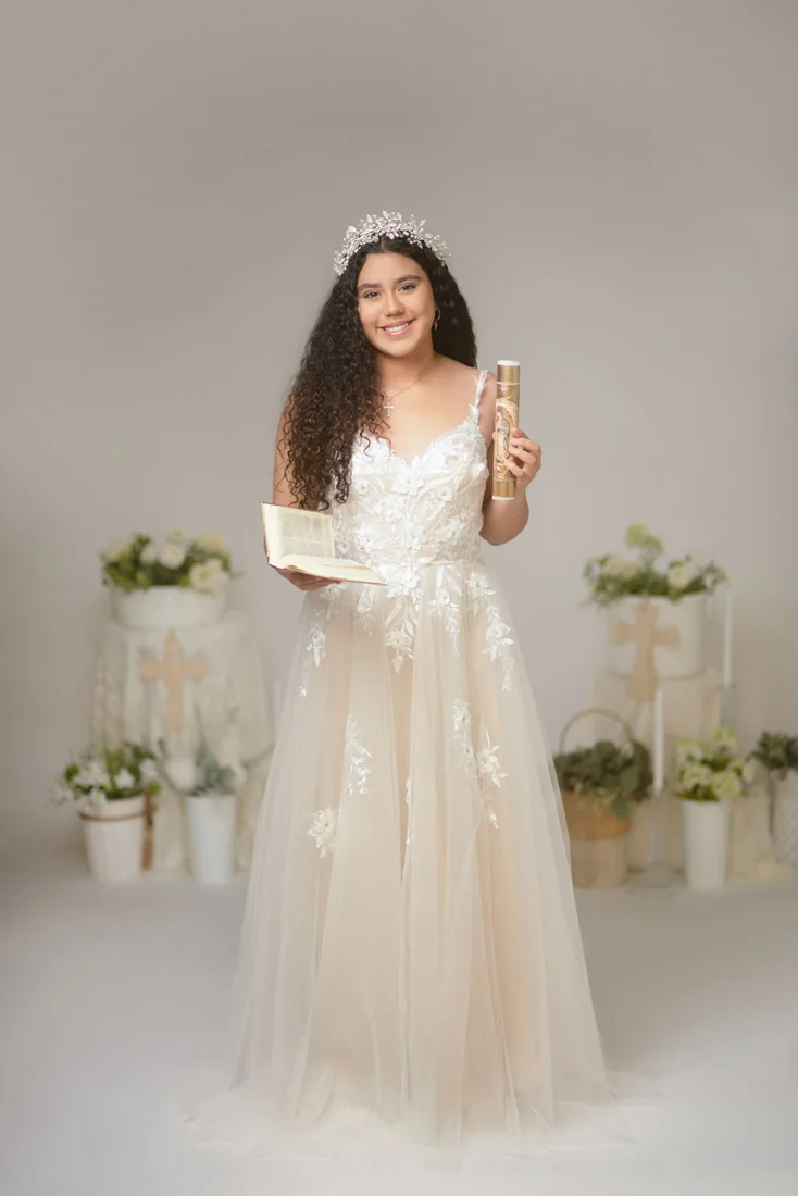 Smiling girl in a white dress against a neutral studio backdrop