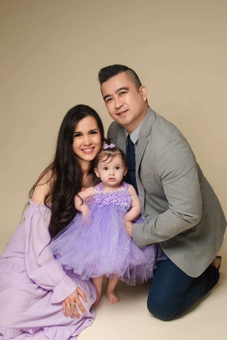 Stephanie with both parents in a seated family studio portrait