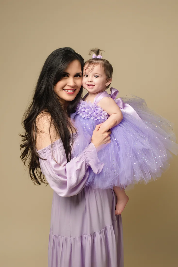 Mother holding Stephanie in coordinating lavender dresses