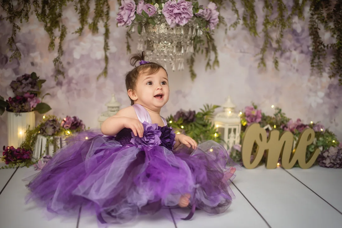 Stephanie looking up with her purple tulle dress spread around her