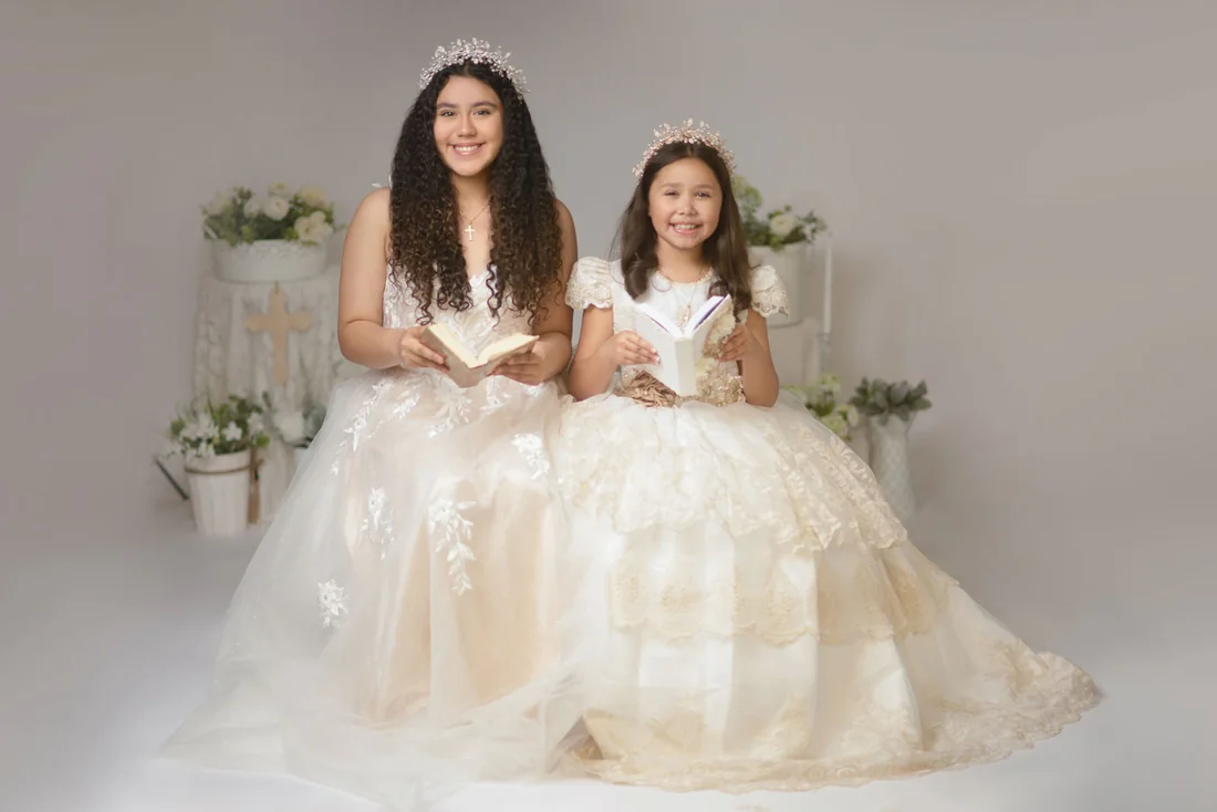 Two girls seated together with an open book and a keepsake